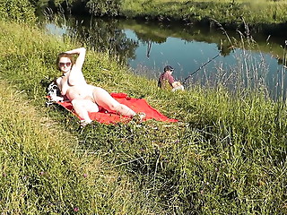 Wild beach. Sexy MILF Platinum naked sunbathing on river bank, random fisherman guy watches. Naked in public. Nude beach